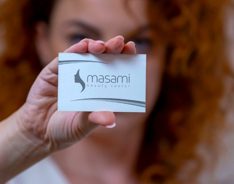 Biglietto da visita Masami Beauty Center tenuto in mano